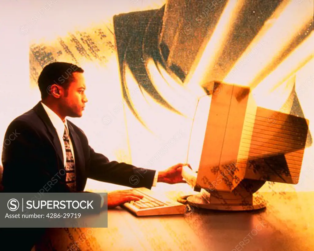 African American businessman using computer with pillar in background.