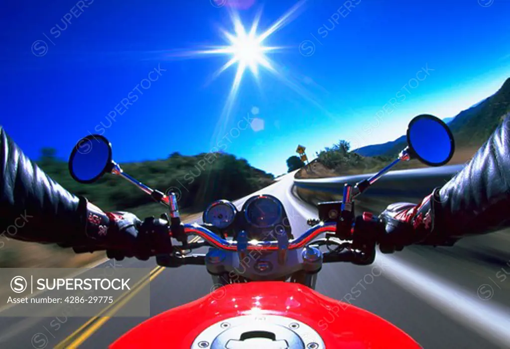 Blurred view as a motorcyclist speeds down a road.