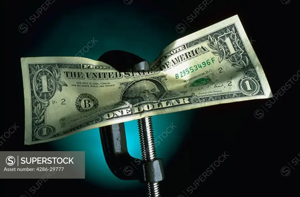 Dollar bill being crunched in a vice.