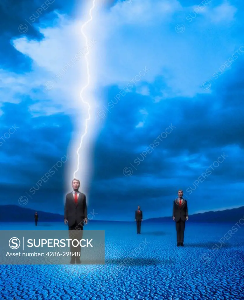 One of several identical businessmen standing on a dry lakebed is struck by a bolt of lightning.