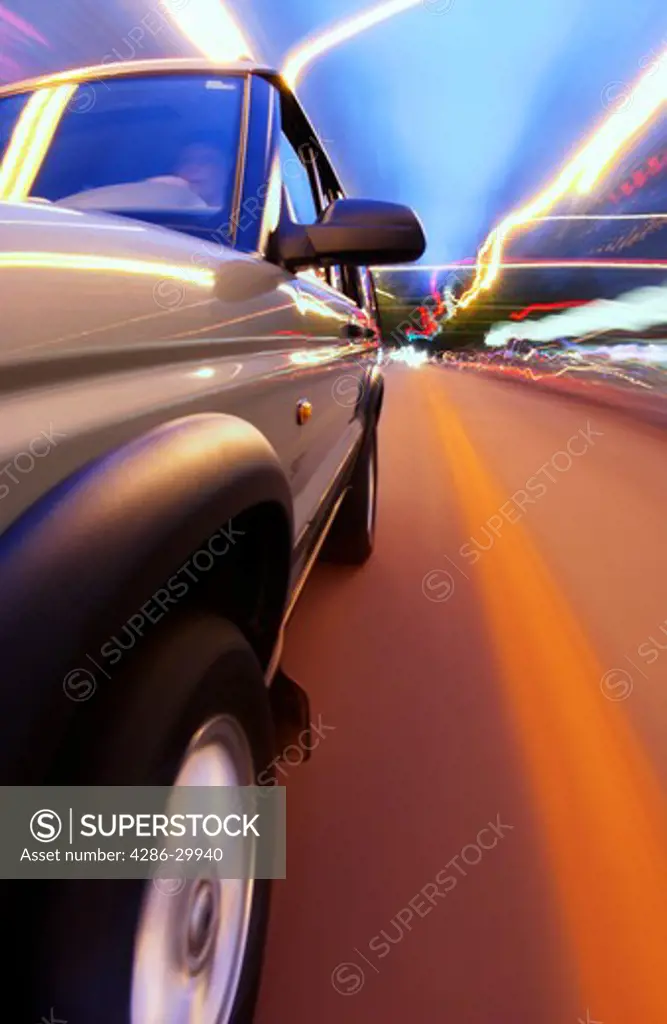 SUV driving with blurred lights and road
