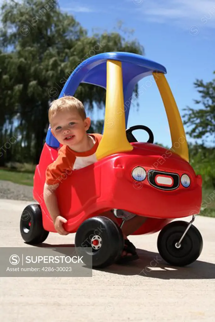 Young boy in toy car