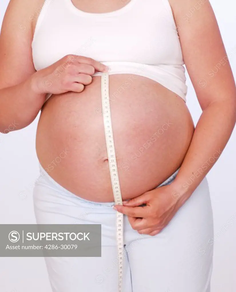 Pregnant woman measuring stomach