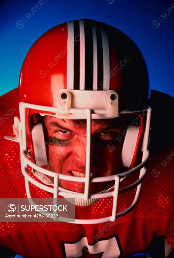 Close-up of angry football player wearing helmet and jersey.