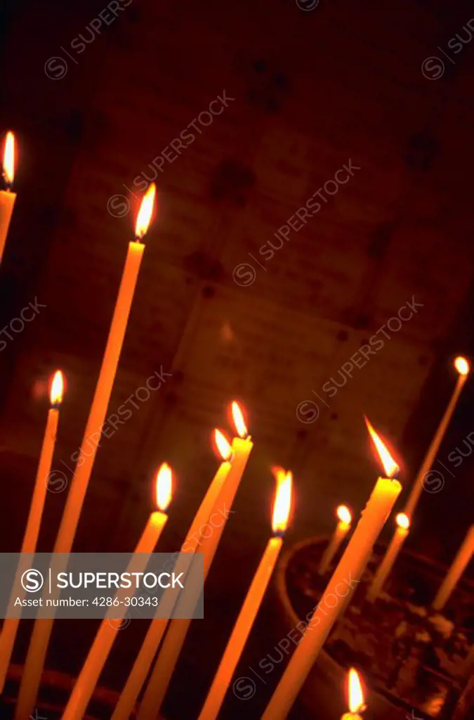 Lit candles burning in  St. Germain Church, Paris, France.