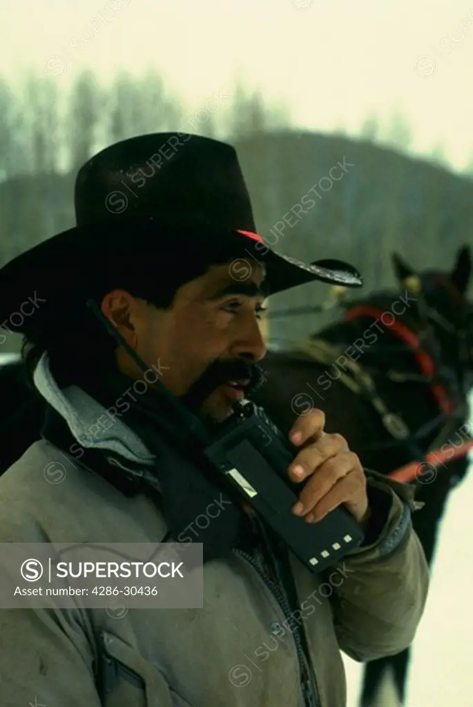 Hispanic cowboy on cellular phone.