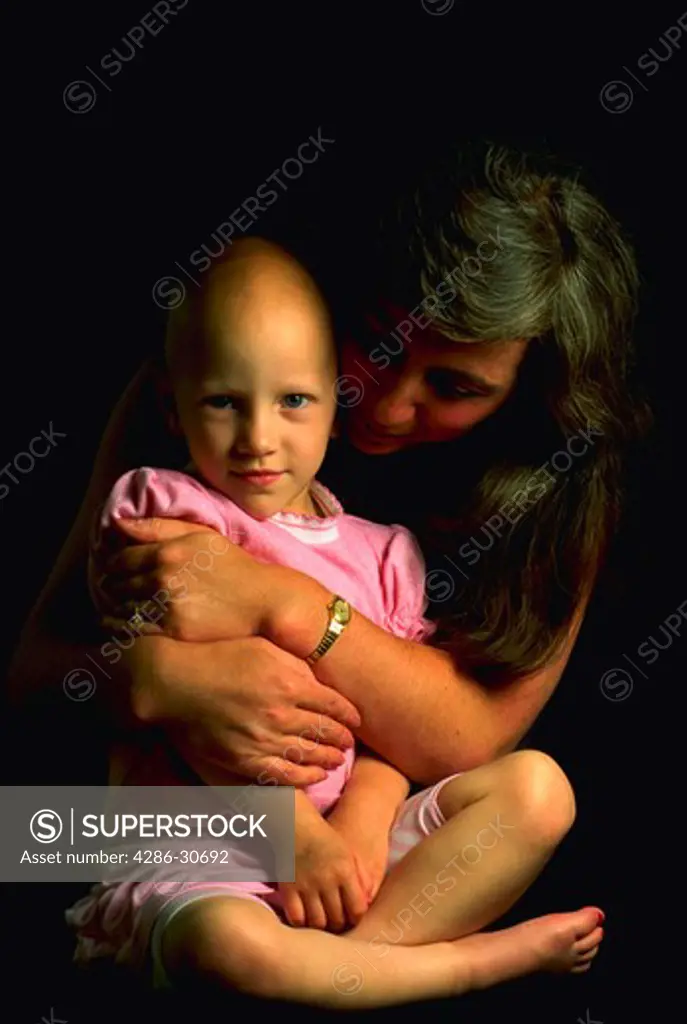 Holding on to life. A young cancer patient and her mother. Chemotherapy treatment.