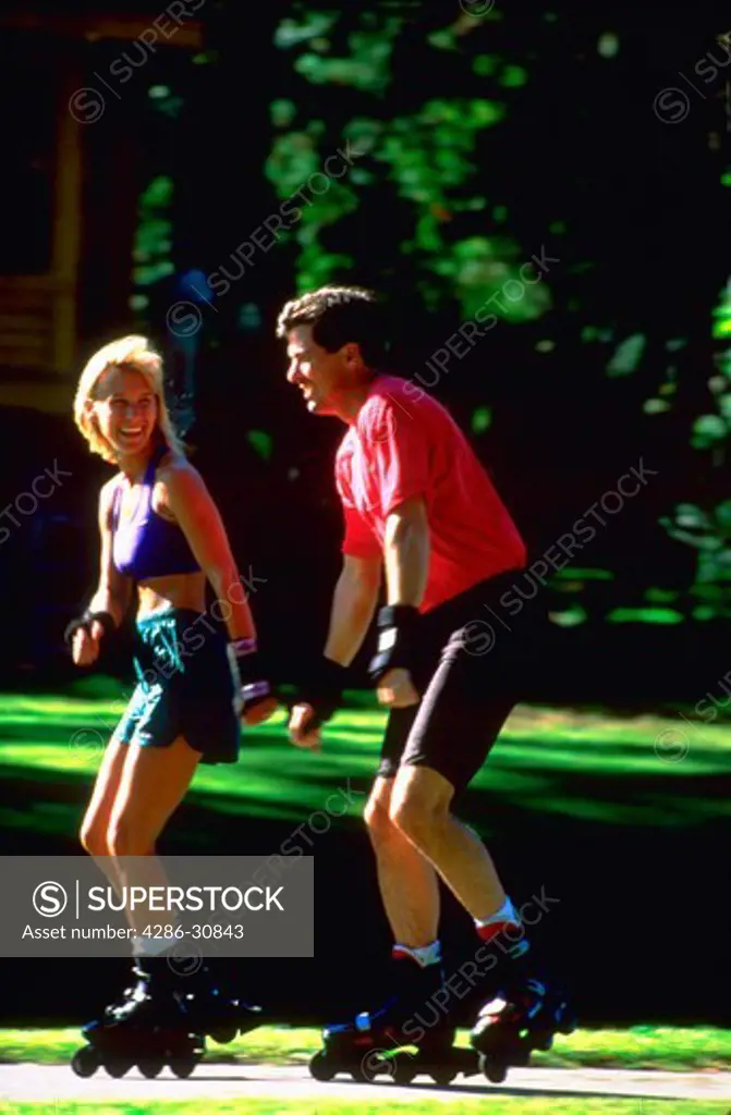 Man and woman rollerblading together.