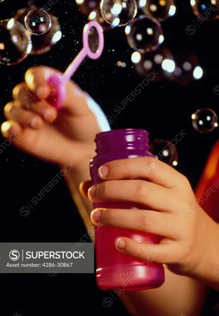 Childs hands blowing bubbles.