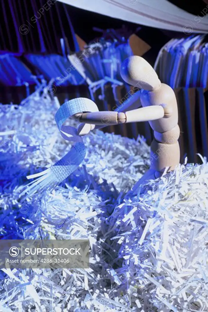 Figurine symbolizing a businessman standing in a pile of shredded paper. 