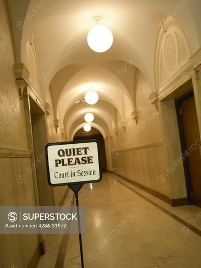 Quiet sign in an empty courthouse hallway.