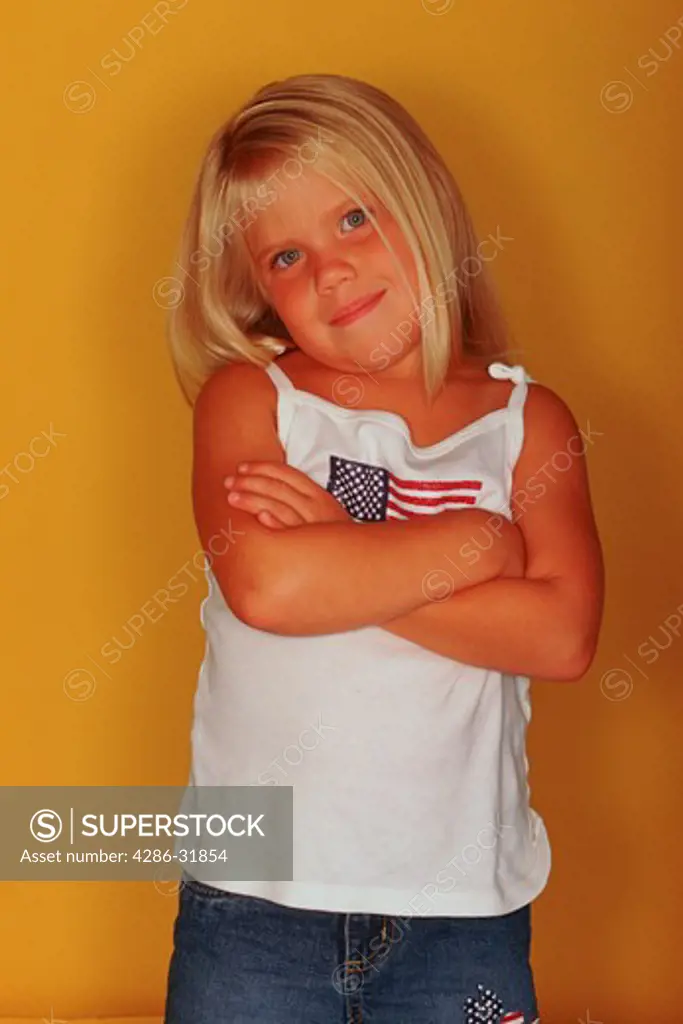 Studio shot of a young, blonde girl posing for the camera. 