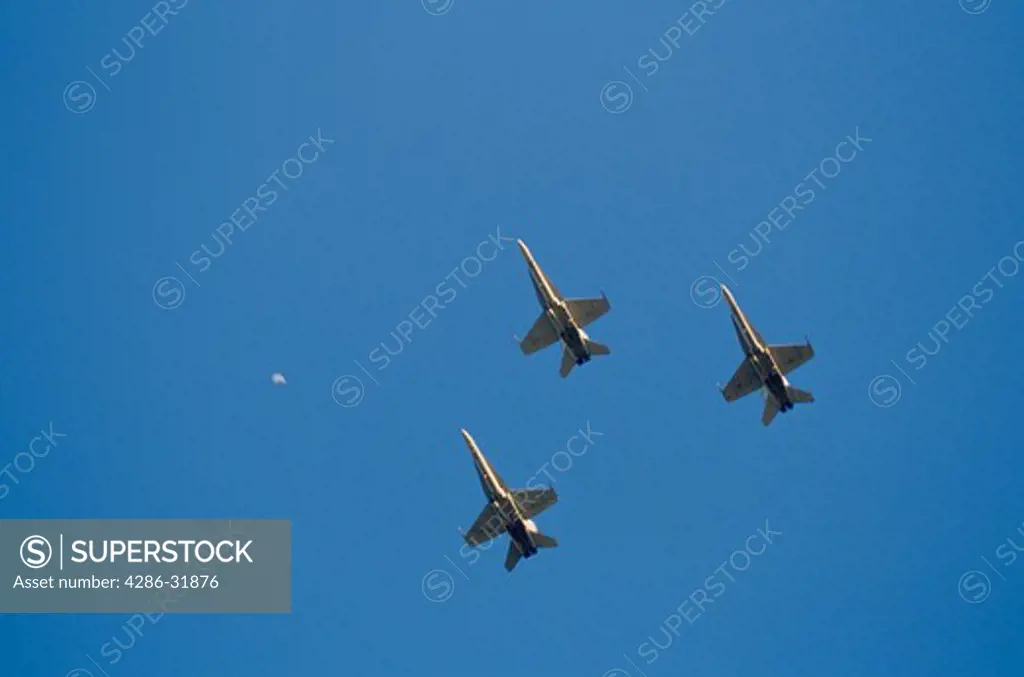 View from below of three military aircraft strike fighters flying in the clear blue skies in Ft. Worth, Texas. 