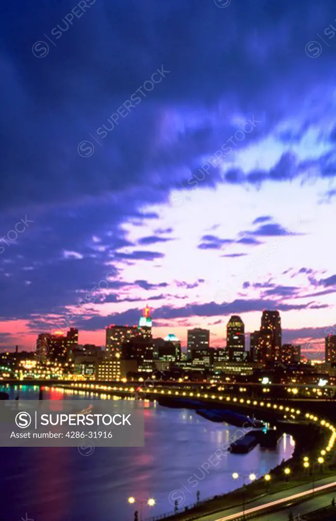 Skyline of St. Paul, Minnesota along the Mississippi River at dusk with dramatic clouds.