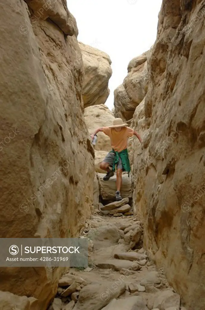Chaco Canyon, New Mexico. Chaco Culture National Historic Park. A visitor scales down the steep rocky cliff trail to Pueblo Alto ruins. Ruins of dwellings of Ancient Puebloan peoples. Commerce center and spiritual meeting place.