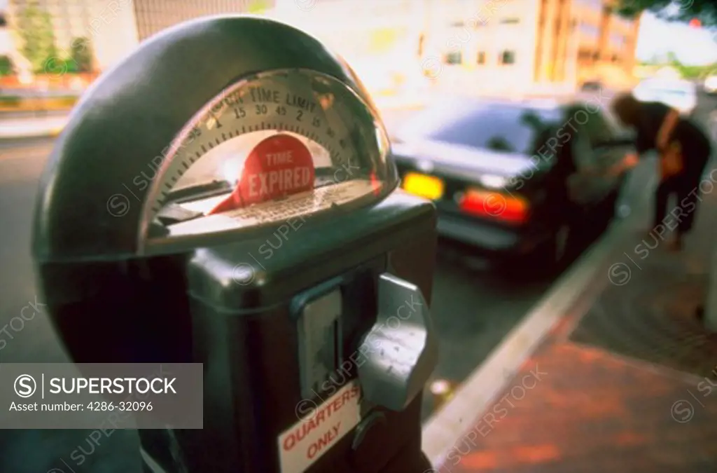 Close-up of an expired parking meter on a busy city street in downtown Albuquerque, New Mexico.
