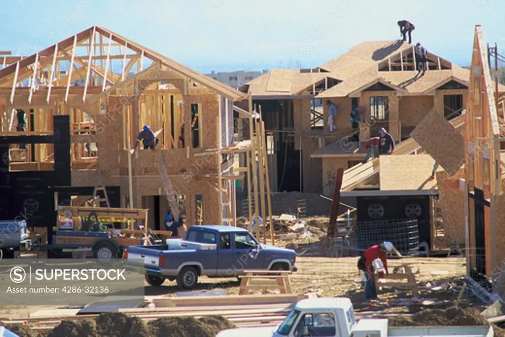 View of construction workers working on the unfinished frames of residential houses in Albuquerque, NM. 