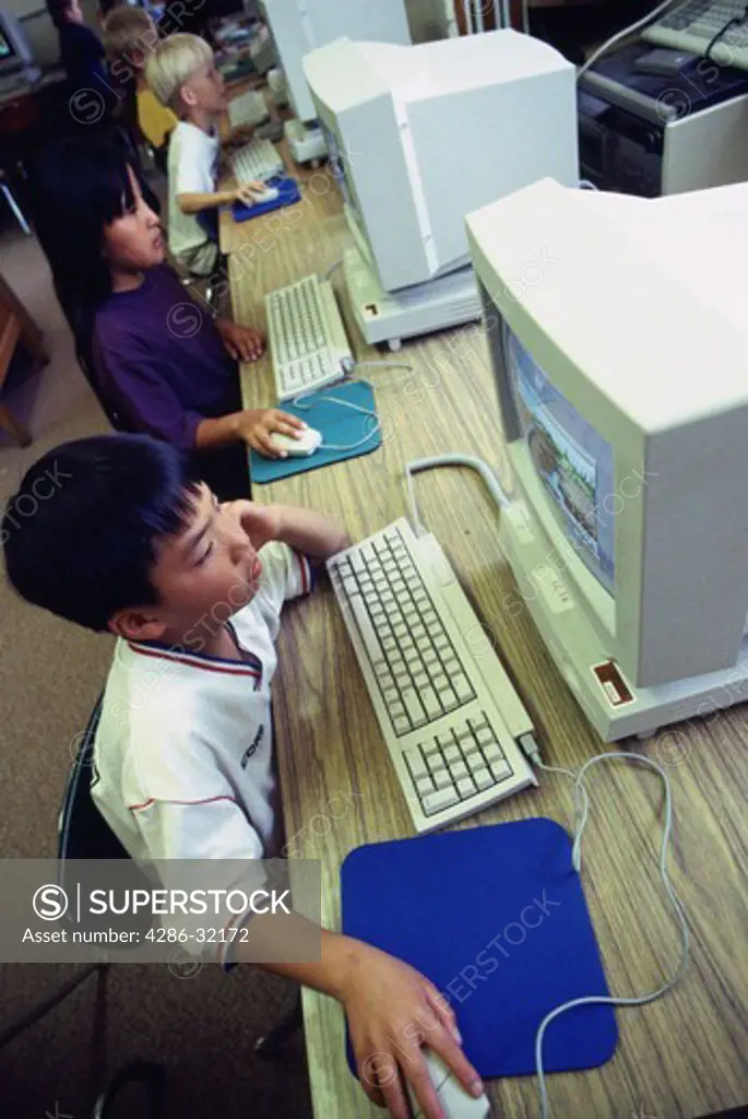 Mixed ethnicity of second grade children working at the computer lab. 