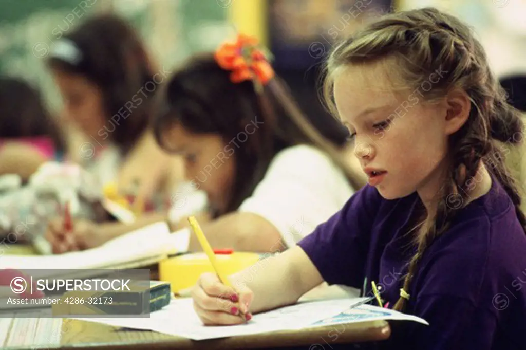 Close-up of a second grade girl working on her math homework. 