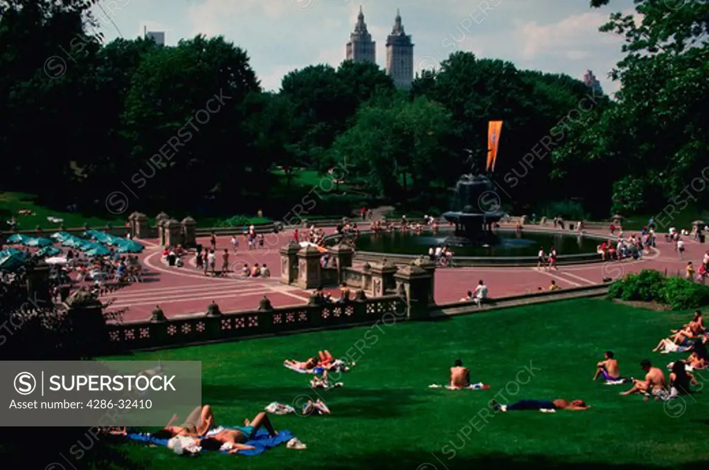 View of people sunbathing near Bethesda Fountain in New Yorks Central Park in the summertime.