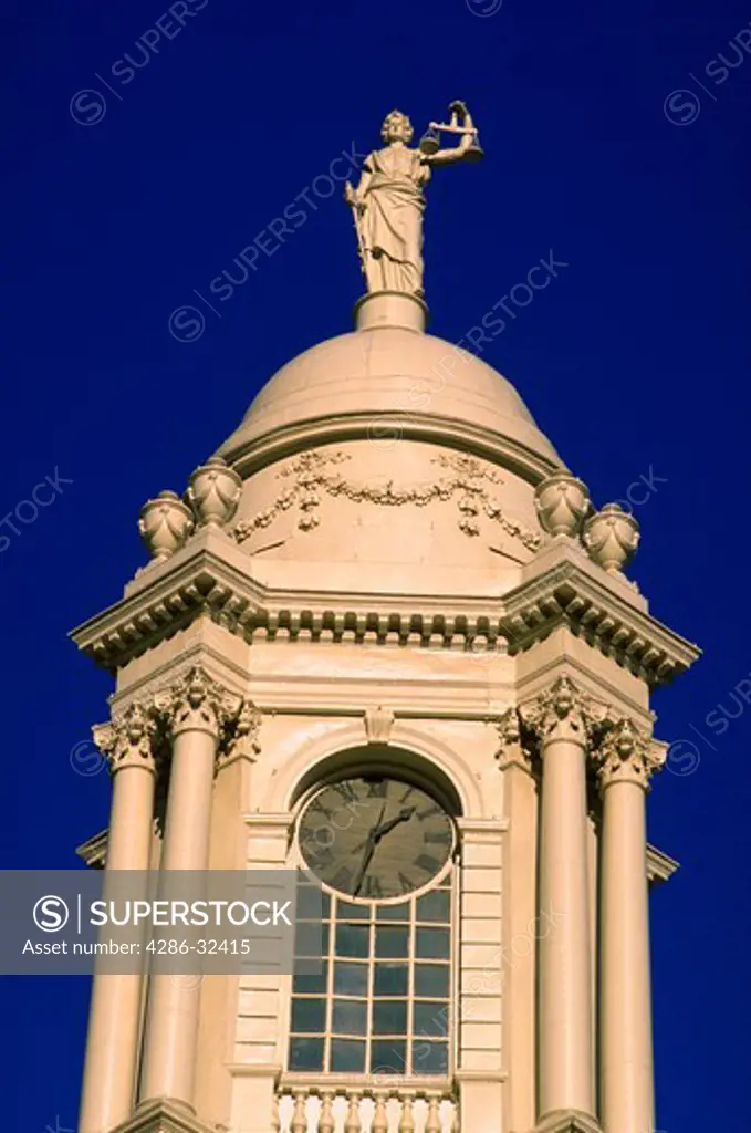 View of the clock and statue of Lady Justice with scales atop the Bell Tower at City Hall in New York City, New York.