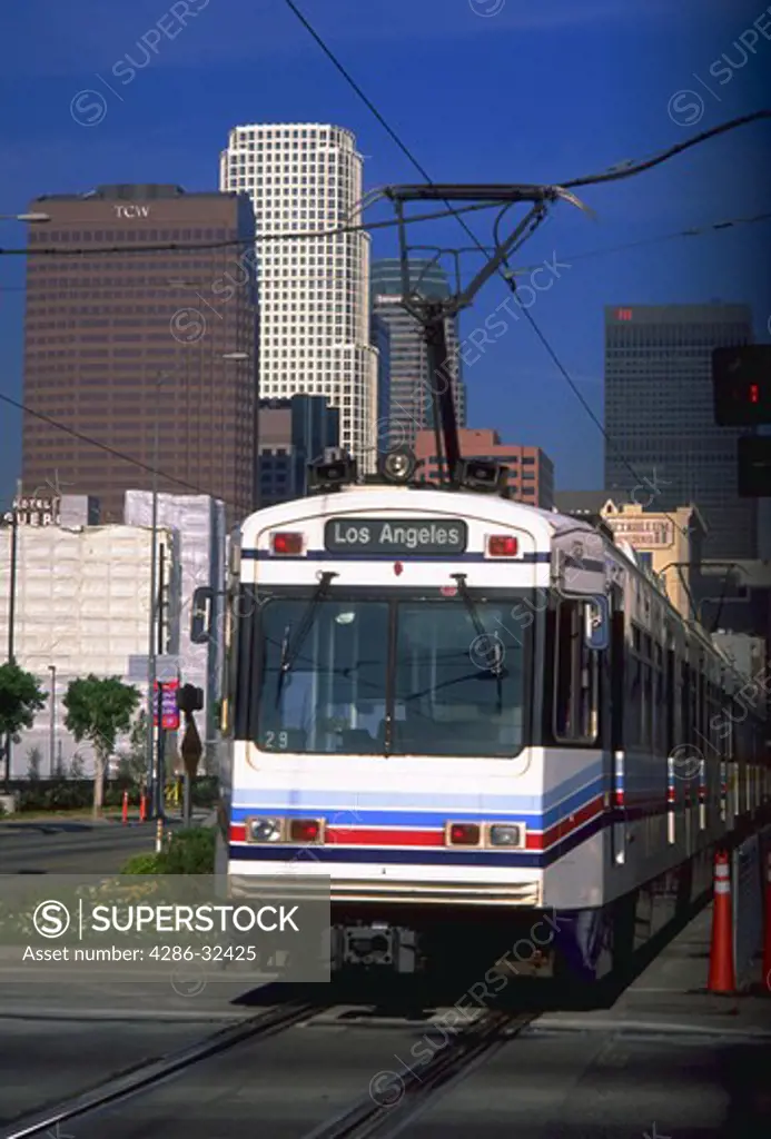 View of an oncoming Metro Train with the Los Angeles, California skyline in the background.