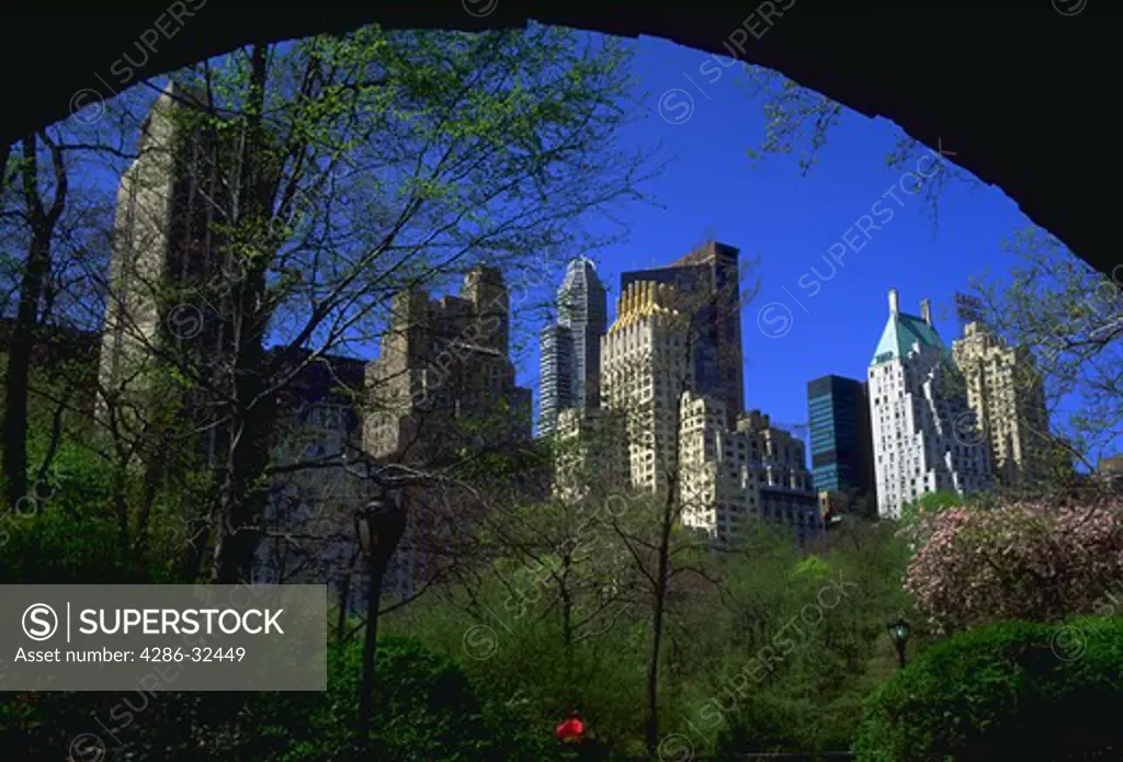 View of the skyline surrounding Central Park South in New York City as seen from beneath an underpass arch, New York.