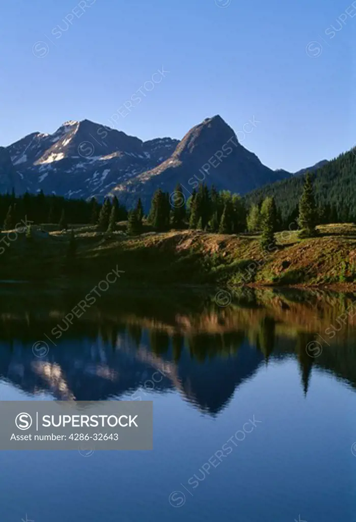 Calm morning reflection of blue sky and mountain peaks in Molas Lake, along the San Juan Skyway south of the town of Silverton, Colorado, Rocky Mountains.