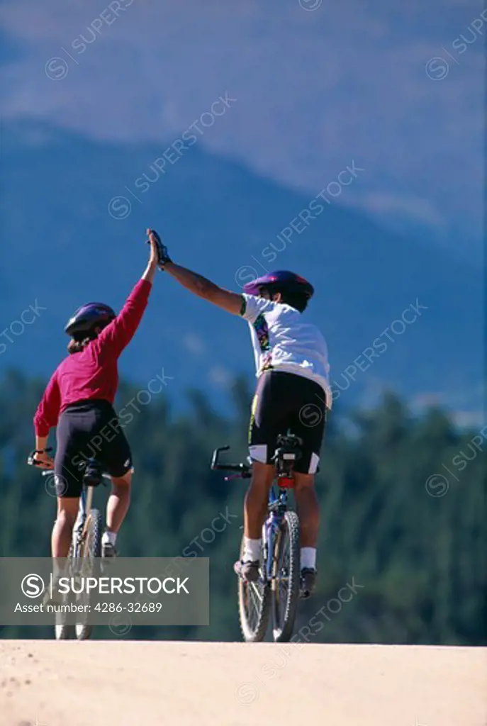 Two people mountain biking.