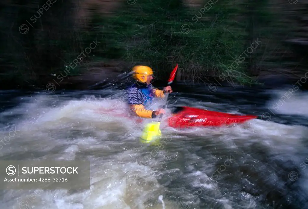 Kayaker in white water, blurred