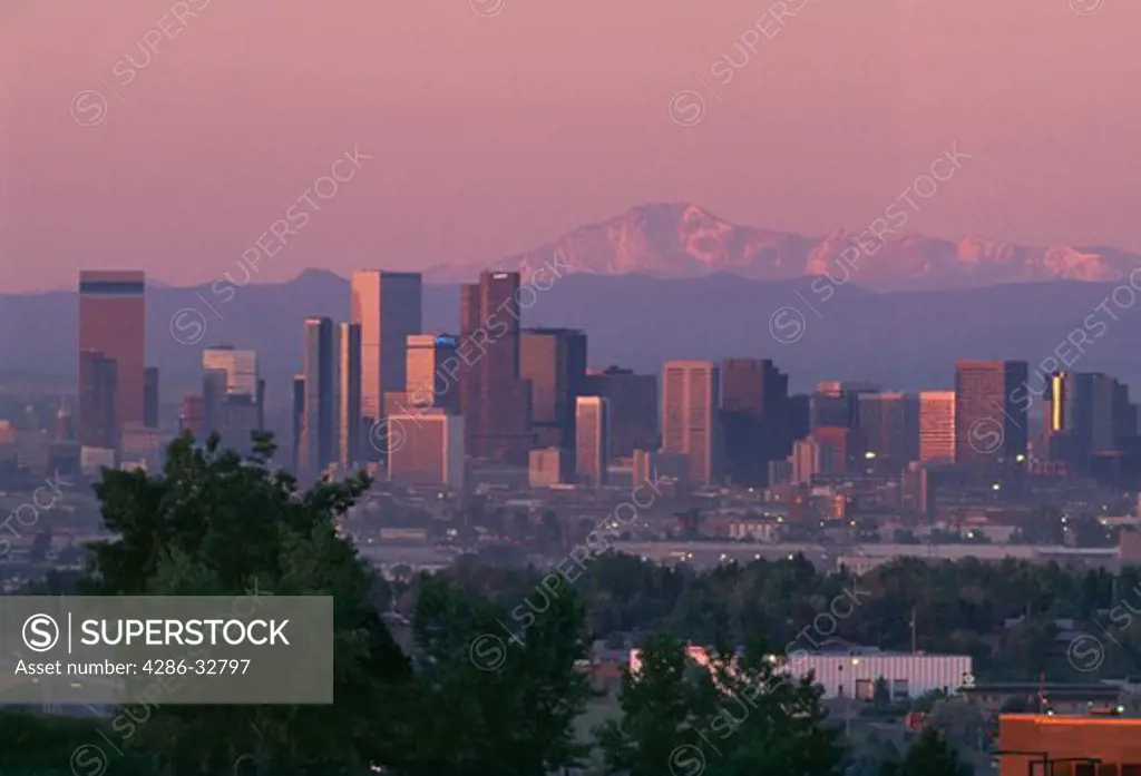 View of the Denver skyline at sunrise on a spring morning with Pikes Peak in the background.