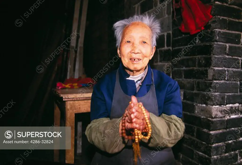 Senior woman with prayer beads; portrait; Cyunsi Buddhist Nunnery; commerce; religion; Chongqing, China, Asia; 041603