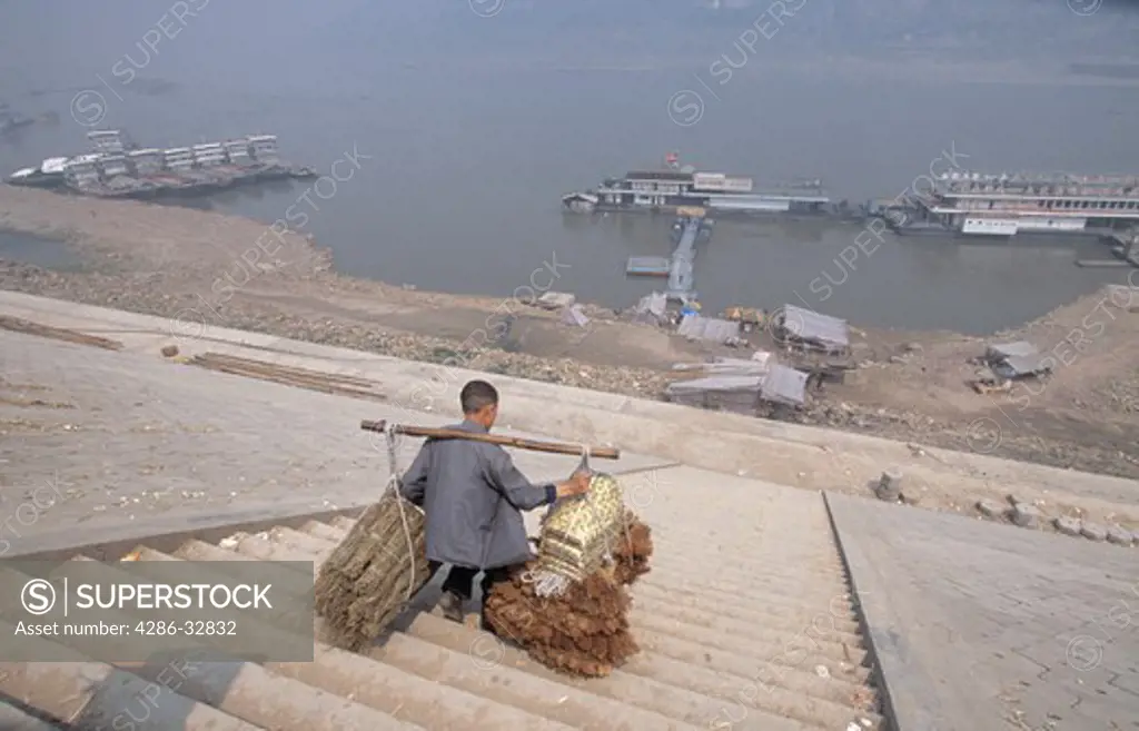 Stick stick man with heavy load on steep stairs; Yangtze River; Fuling, China, Asia; city impacted by 3 Gorges Dam; 041703