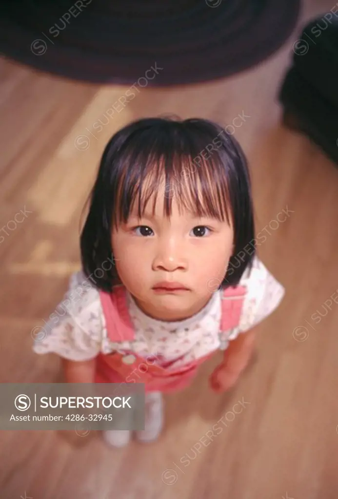 A young Asian girl looking up with a glum expression on her face, Estes Park, CO