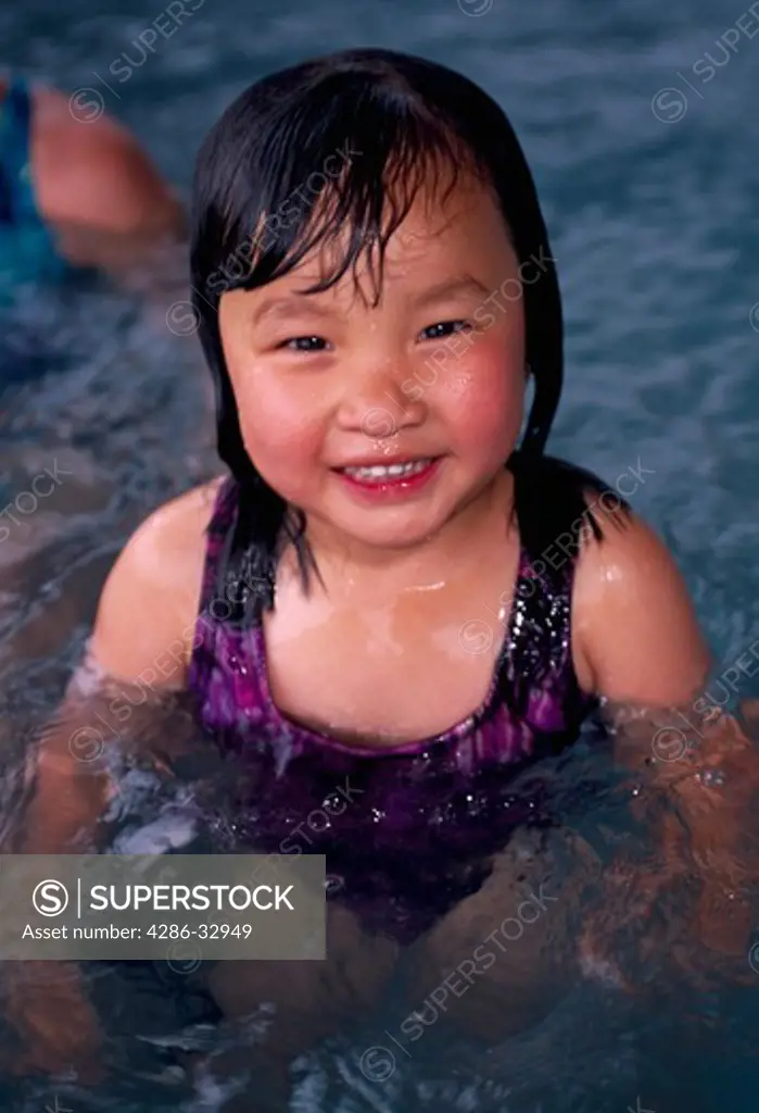 Young Asian girl smiling while in hot tub, Estes Park, CO