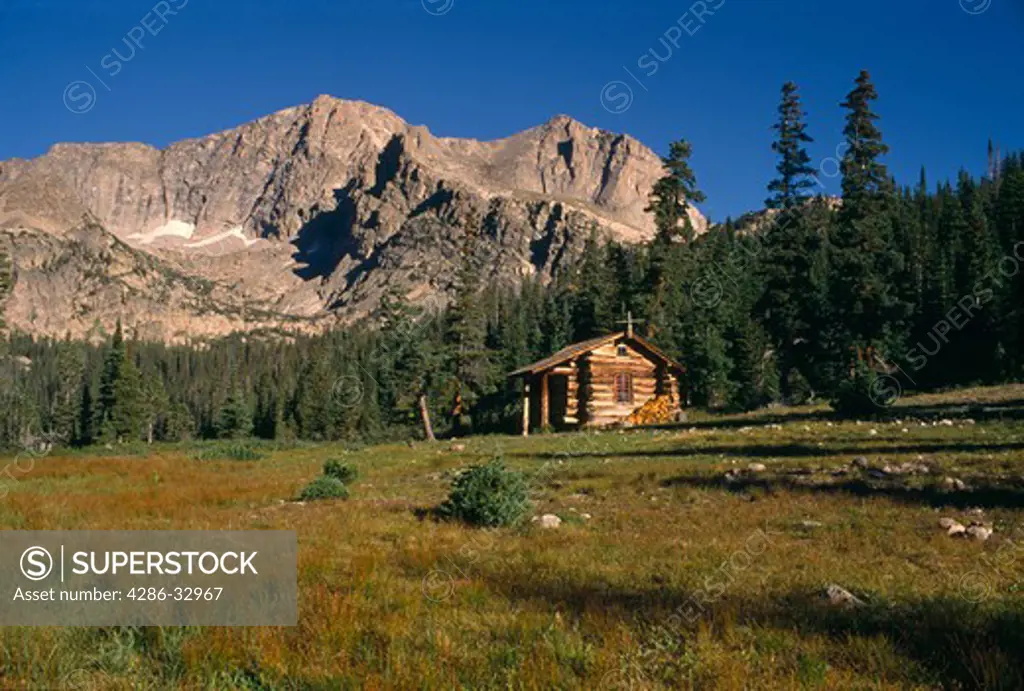 A rustic cabin sits beneath Mt Alice near Thunder Lake in Rocky Mountain National Park, CO