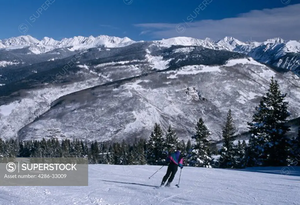 Downhill skier on slopes near the Gore Range, Vail, Colorado