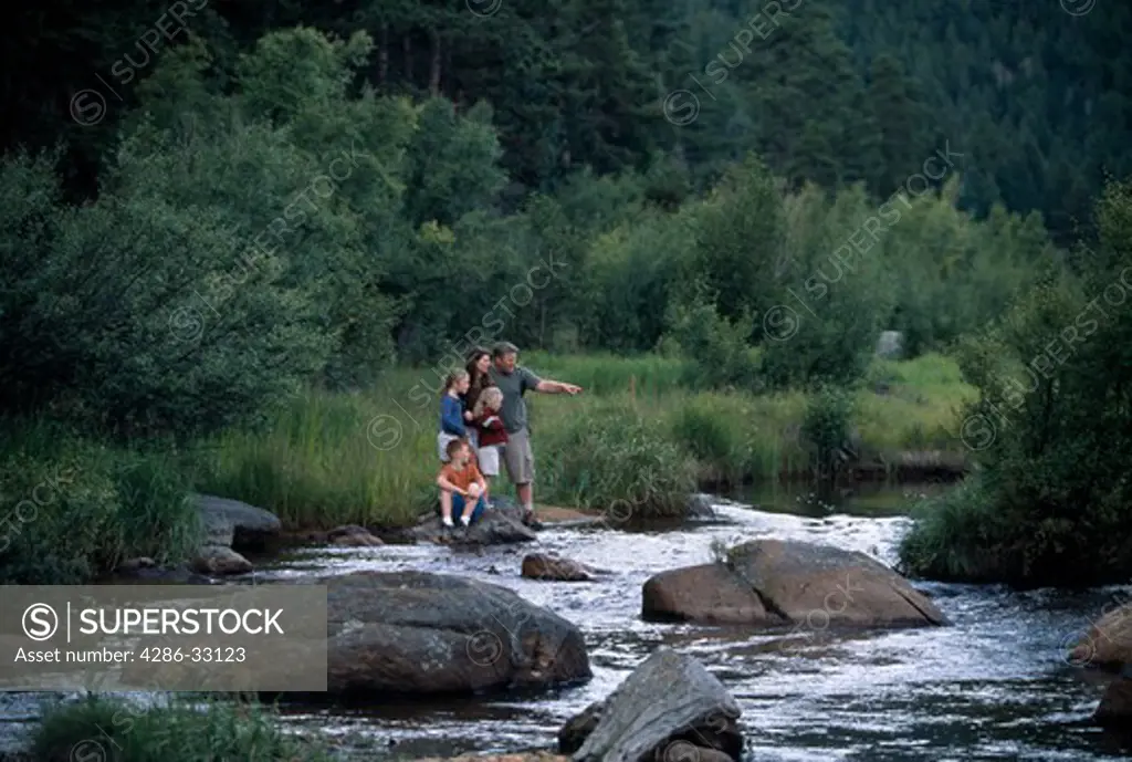 Family of five explore river habitat along Big Thompson River, Moraine Park, Rocky Mtn Nat'l Park, CO