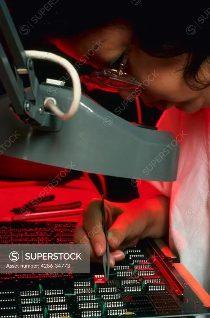 Technician works on computer boards at Point Four Company in California