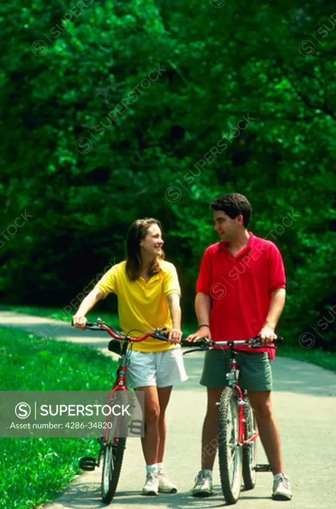 Couple riding bikes in woods, Bethesda, Maryland.  (model released)