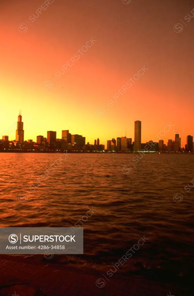 Chicago skyline with Lake Michigan in foreground at sunset, posterized.