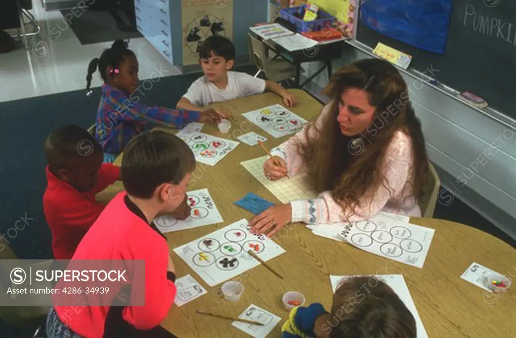 Volunteer mother teaching first grade, counting candy.  (model released)