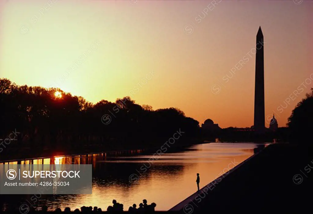 The reflecting pool infront of the Lincoln Memorial at sunrise with the Washington Monument and the U.S. Capitol in the background. - BC31587