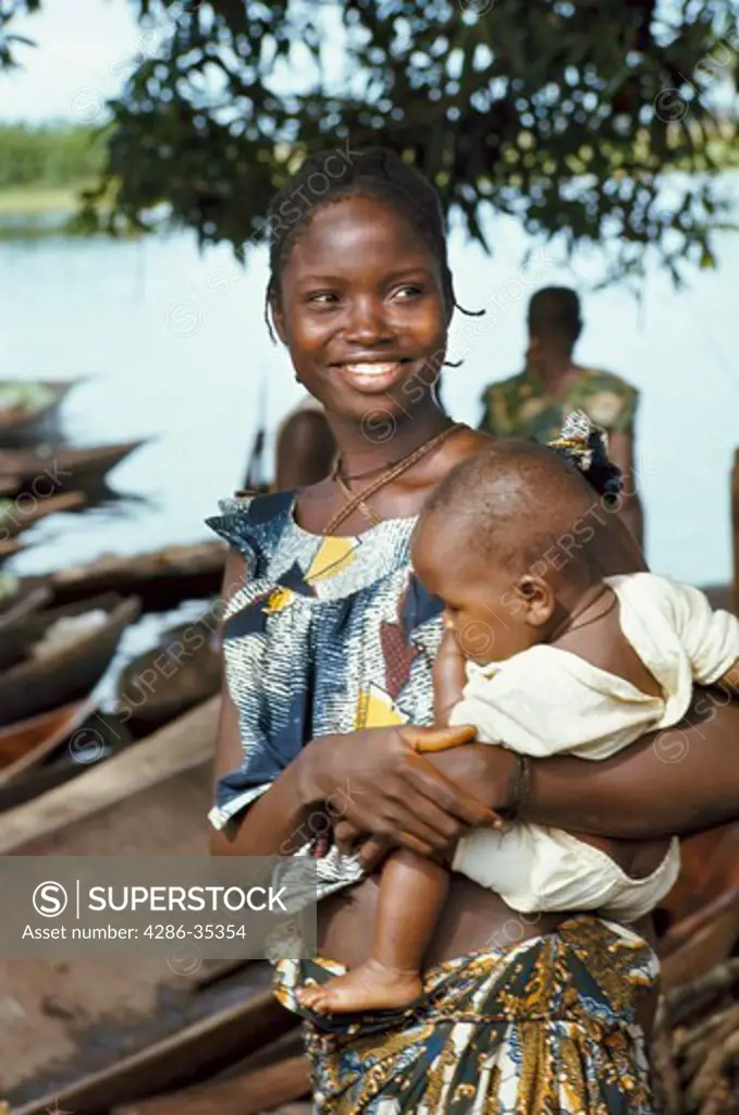 Portrait of smiling woman carrying baby along Ngiri River, Democratic Republic of the Congo (ex-Zaire), Africa.