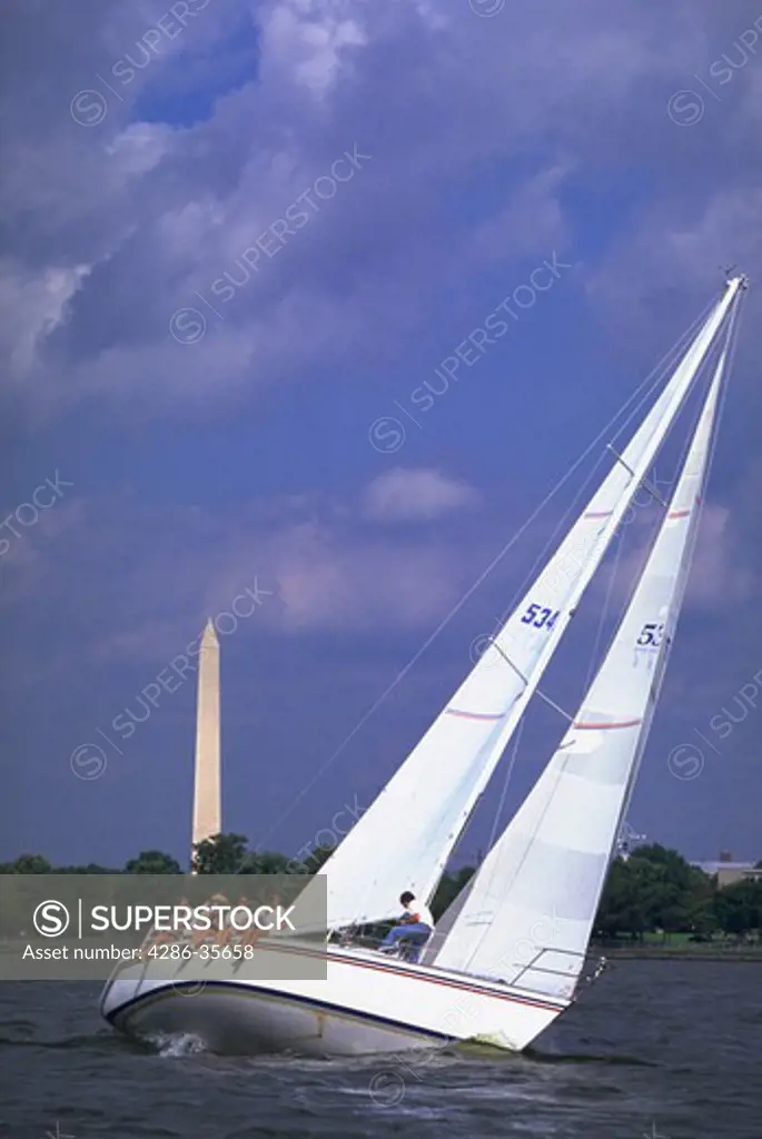 Sailing on the Potomac River in the Nations capital.  Washington, DCs Washington Monument is prominent in the background.  Sailboat showing lots of action/motion while participating in a race called the 52 Regatta. (Recreation.  Washington, DC.  Water Series.  Good Life.)
