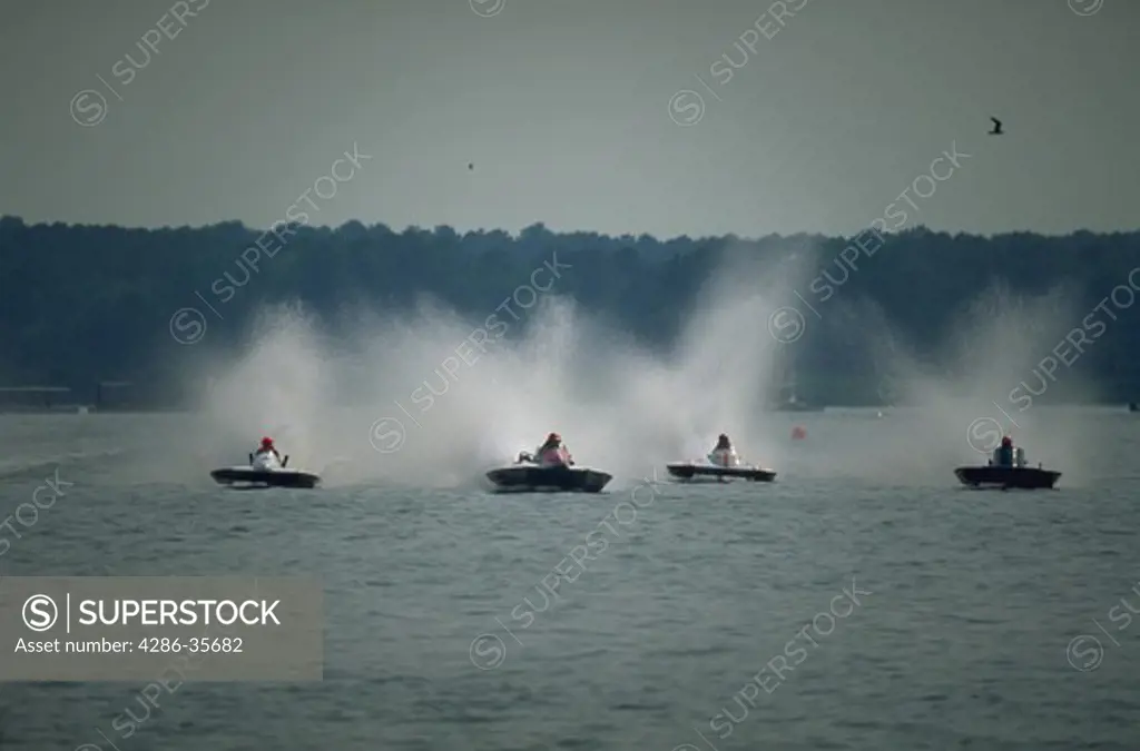 Hydroplane boats racing at Kent Narrows in the Chesapeake Bay.  Action shot showing heated head-to-head competition, and four boats in contention to win.  (Water Series.  Recreation.  Sports.  Boating.  Competition.)