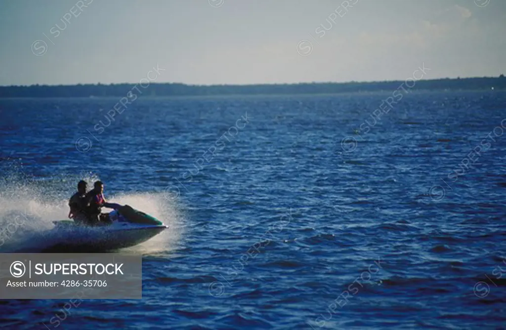 Man riding a personal watercraft (PWC, jet ski or waverunner), on Rehoboth Bay, Delaware. 
