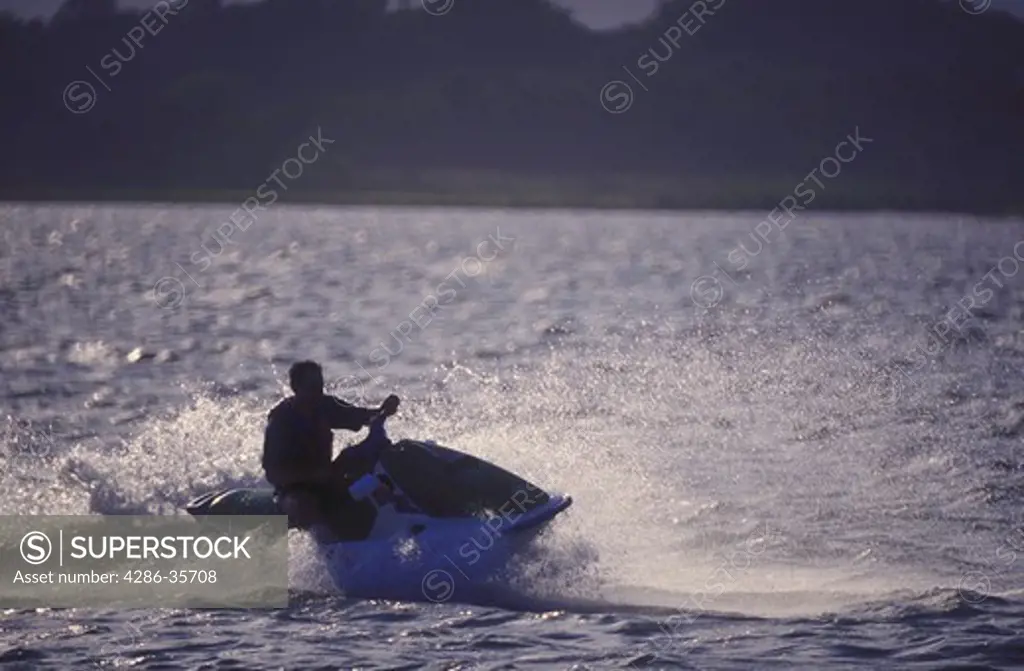 Man riding on a personal watercraft (PWC, also known as jet ski or waverunner).  Taken on Rehoboth Bay, Delaware.  
