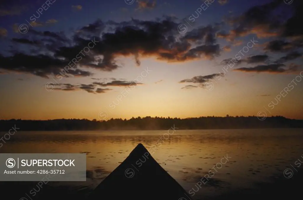 Front of canoe, pointing toward far side of lake, seconds before sunrise.  Taken on Sabbathday Lake, in Maine. 