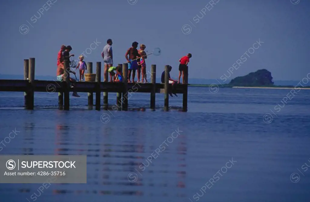 Vacationers on one of the docks on Rehoboth Bay, Delaware.  Adults, kids, all ages.  (Water.  Leisure.  People.)